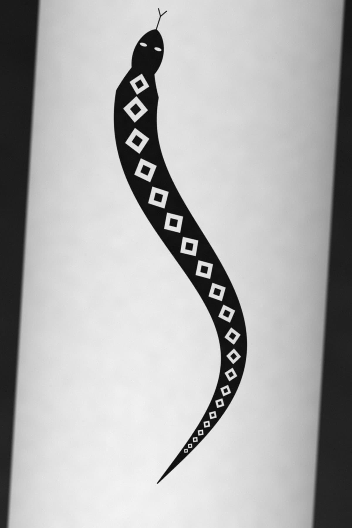 Tatuagem blackwork de uma serpente em preto sólido com escamas em losango no antebraço